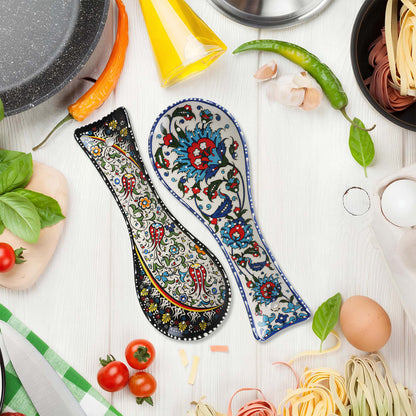 Decorative ceramic spoon rests with floral patterns on a kitchen counter with cooking ingredients.