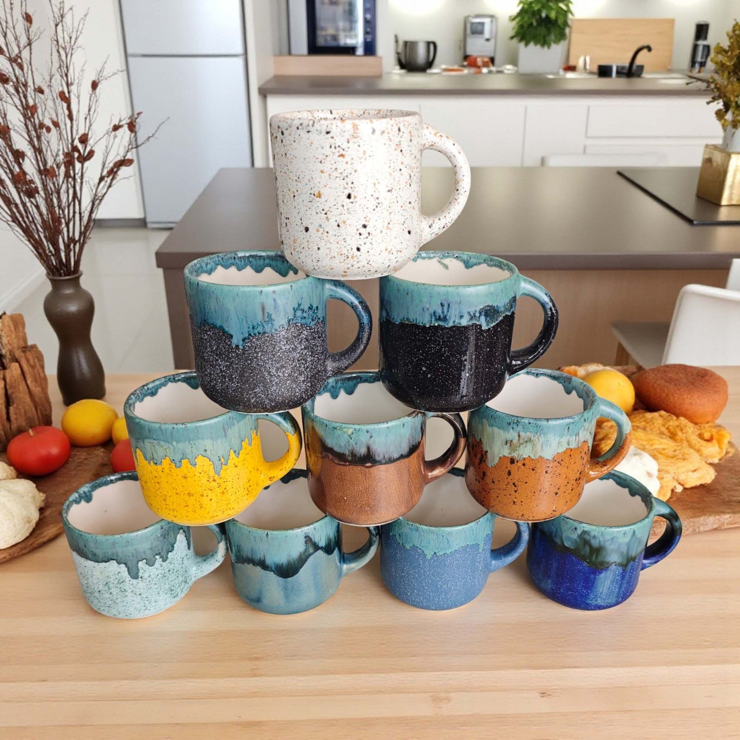 Colorful ceramic mugs stacked on a kitchen counter