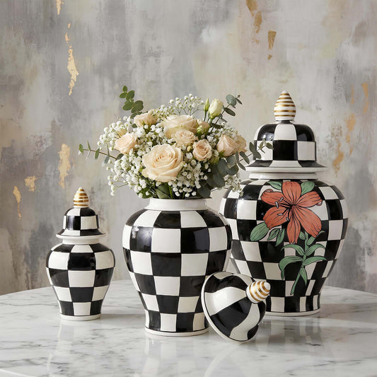 Decorative black and white checkered jars with floral designs on a marble surface.