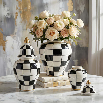 Decorative black and white checkered jars with a floral arrangement on a marble surface.