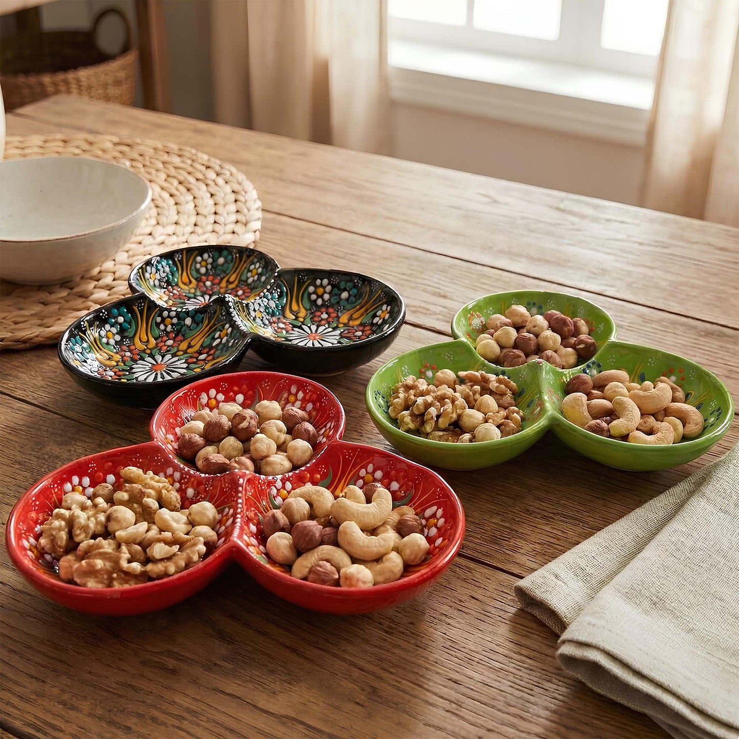 Colorful ceramic trays filled with nuts on a wooden table.