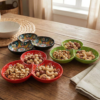 Colorful ceramic trays filled with nuts on a wooden table.