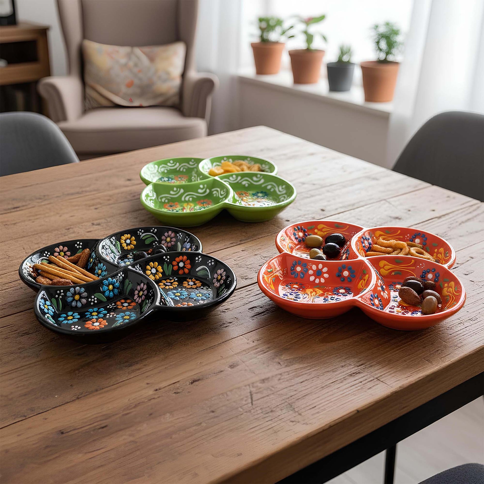 Set of colorful ceramic plates on a wooden table with snacks.