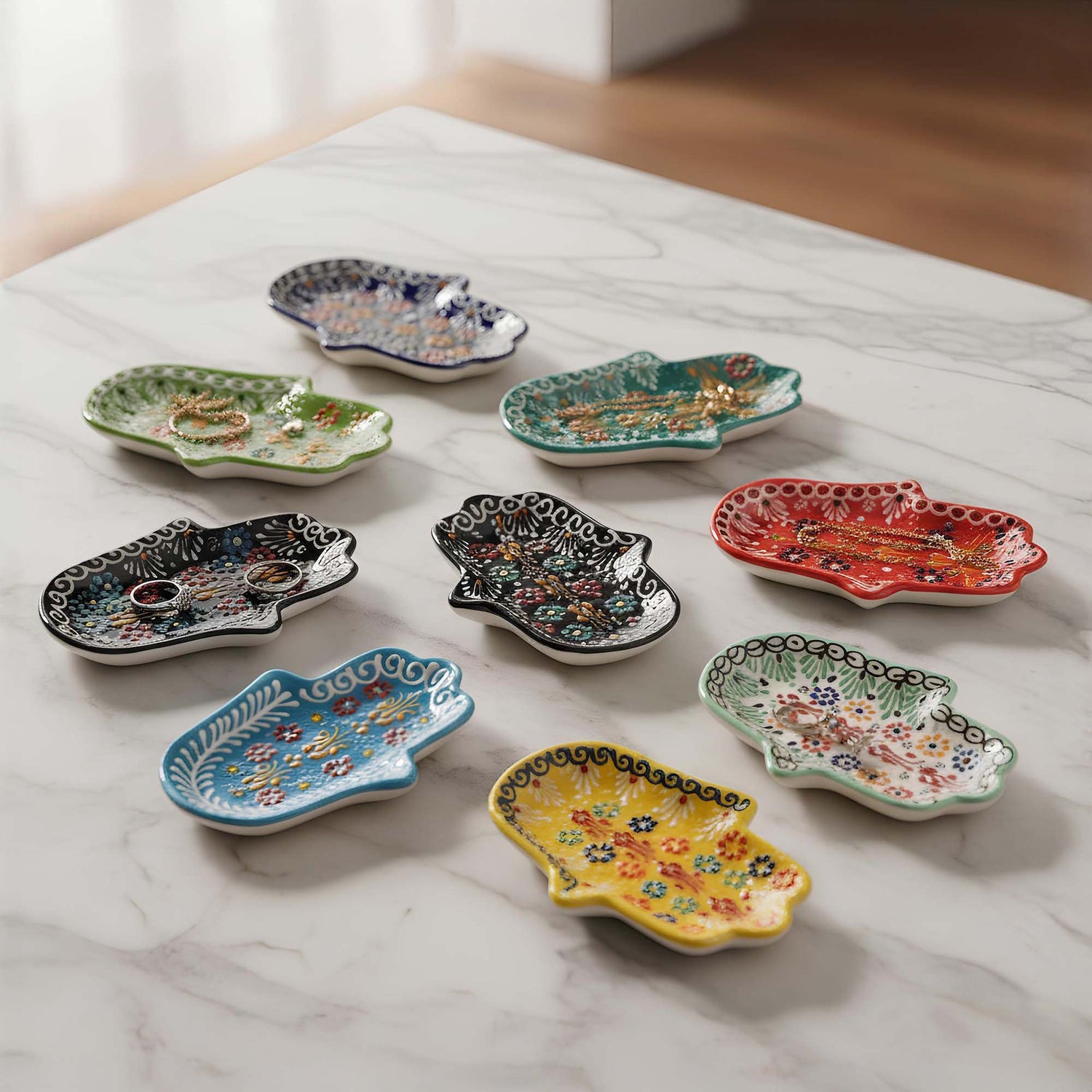 Set of colorful ceramic jewelry trays on a marble surface