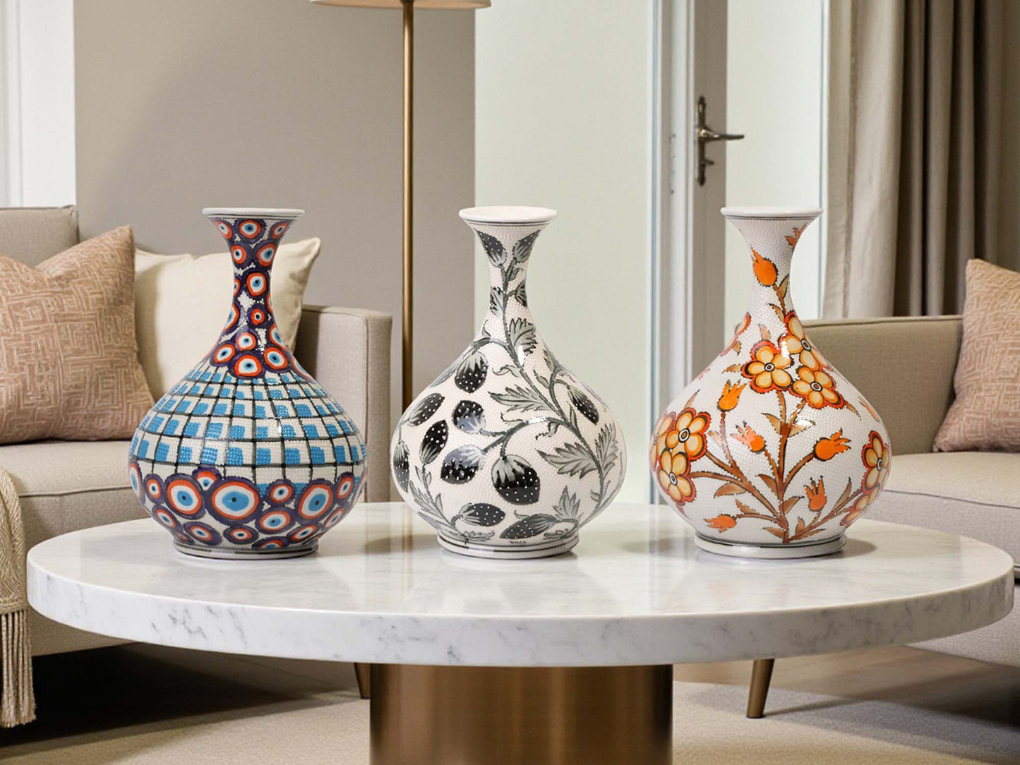 Three decorative vases on a marble table in a living room setting.