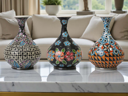 Three decorative vases with intricate patterns on a marble surface.