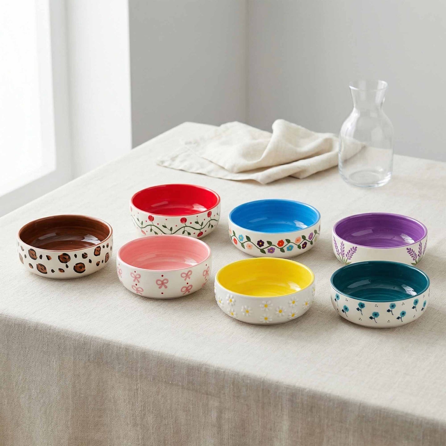 Set of colorful ceramic bowls on a table with a neutral background