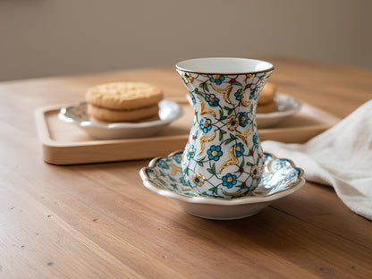 Decorative ceramic cup with floral patterns on a wooden table.