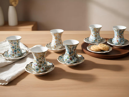 Set of floral teacups and saucers on a wooden table with a soft background