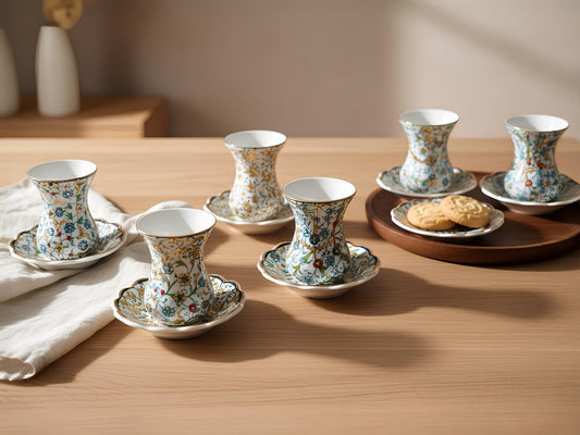 Set of floral teacups and saucers on a wooden table with a soft background