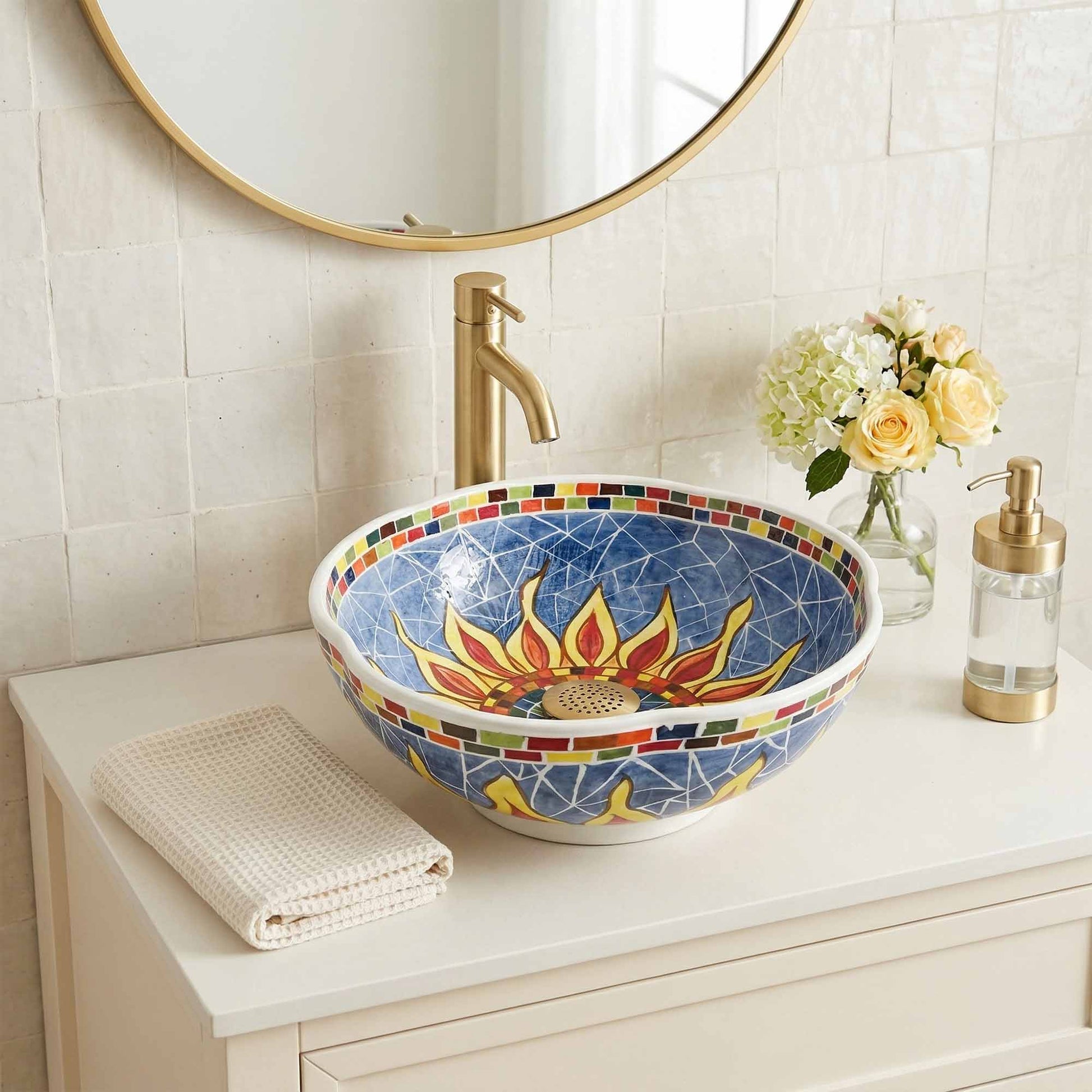 Colorful mosaic ceramic sink on a bathroom counter with a round mirror above.