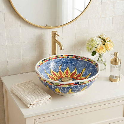 Colorful mosaic ceramic sink on a bathroom counter with a round mirror above.