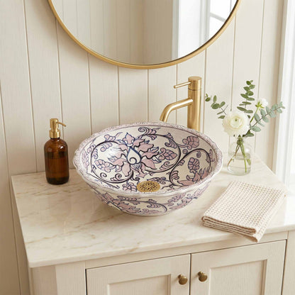 Decorative sink with floral patterns on a marble countertop in a bathroom setting.