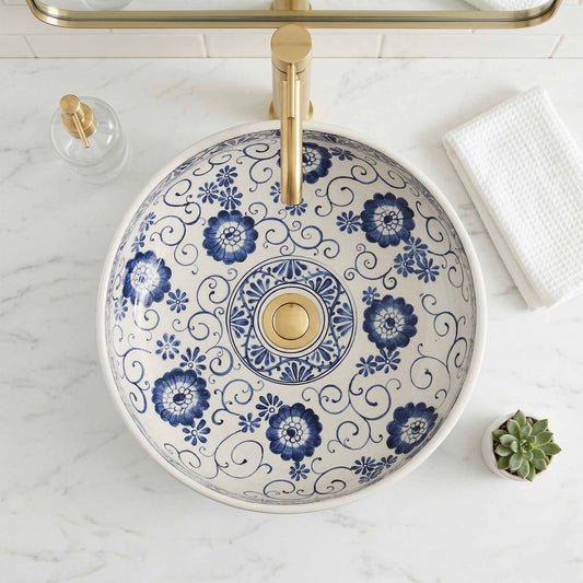 Decorative bathroom sink with blue floral patterns on a marble countertop.