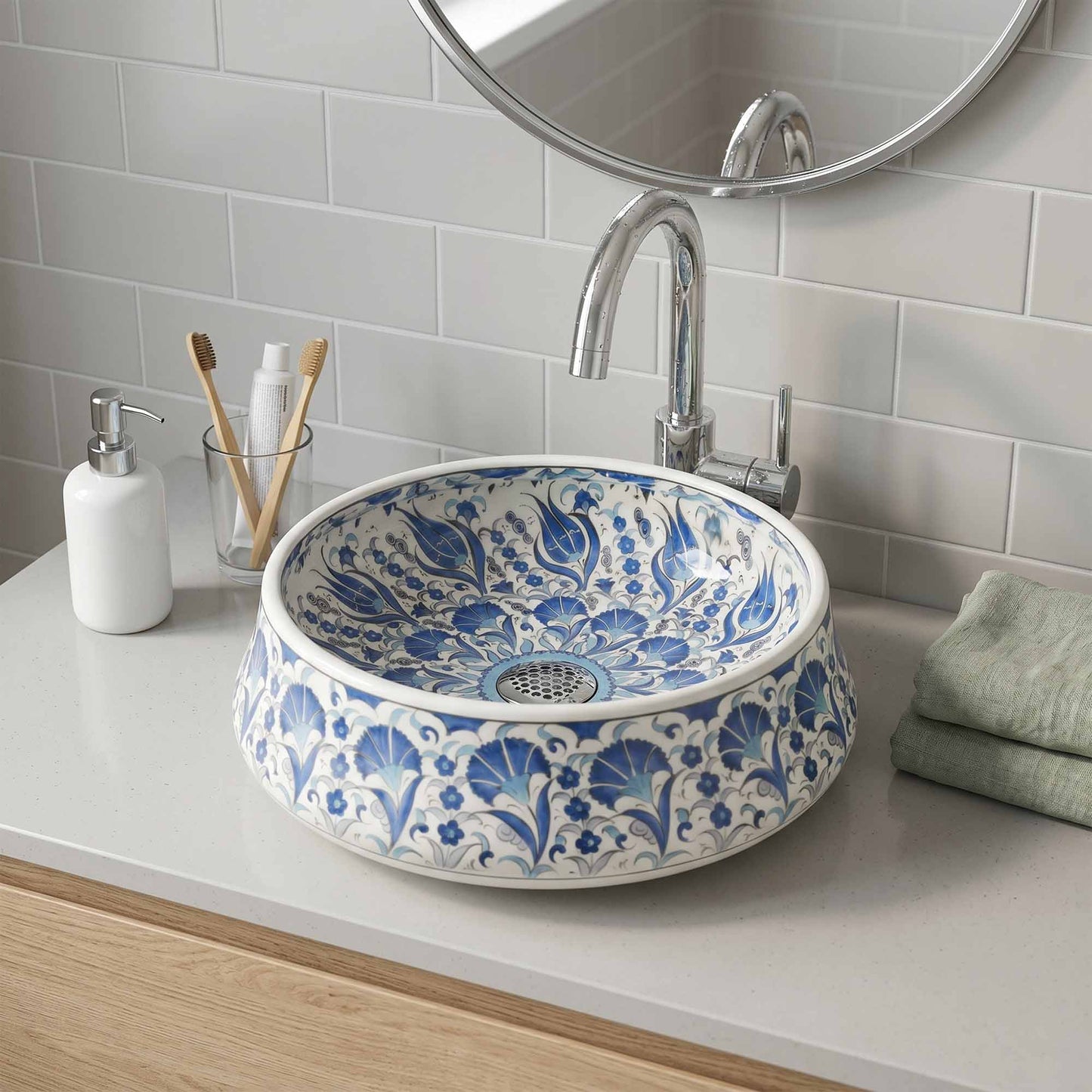 Bathroom sink with blue floral pattern, faucet, and toiletries on a white countertop.