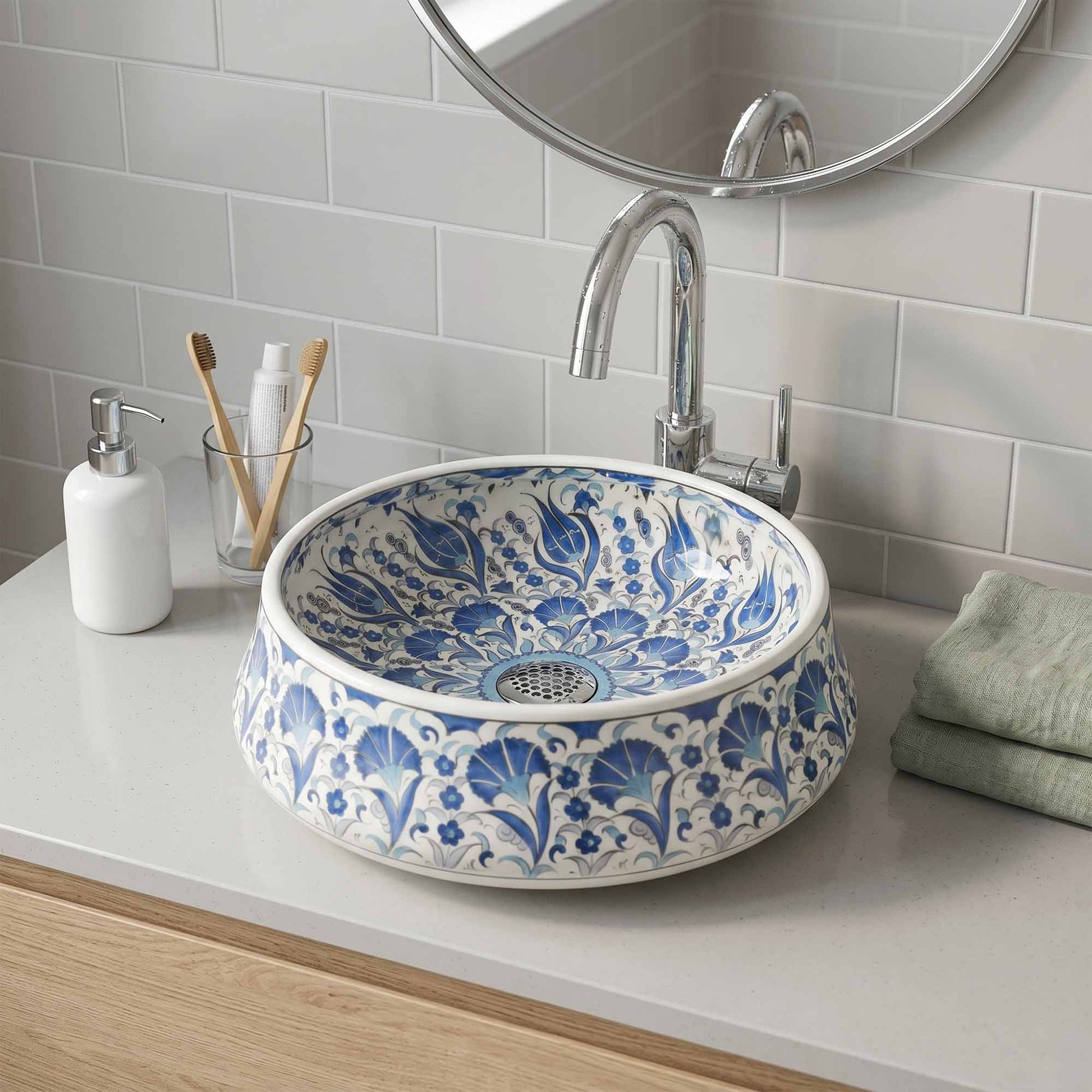 Bathroom sink with blue floral pattern, faucet, and toiletries on a white countertop.