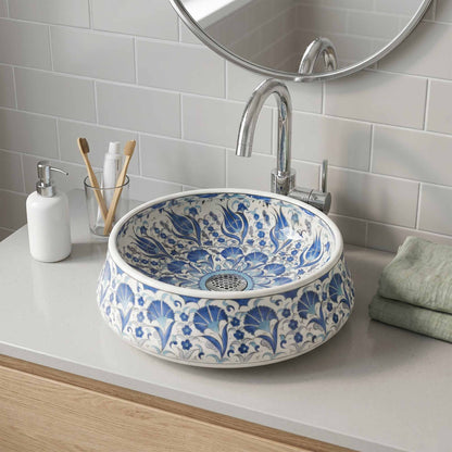 Bathroom sink with blue floral pattern, faucet, and toiletries on a white countertop.