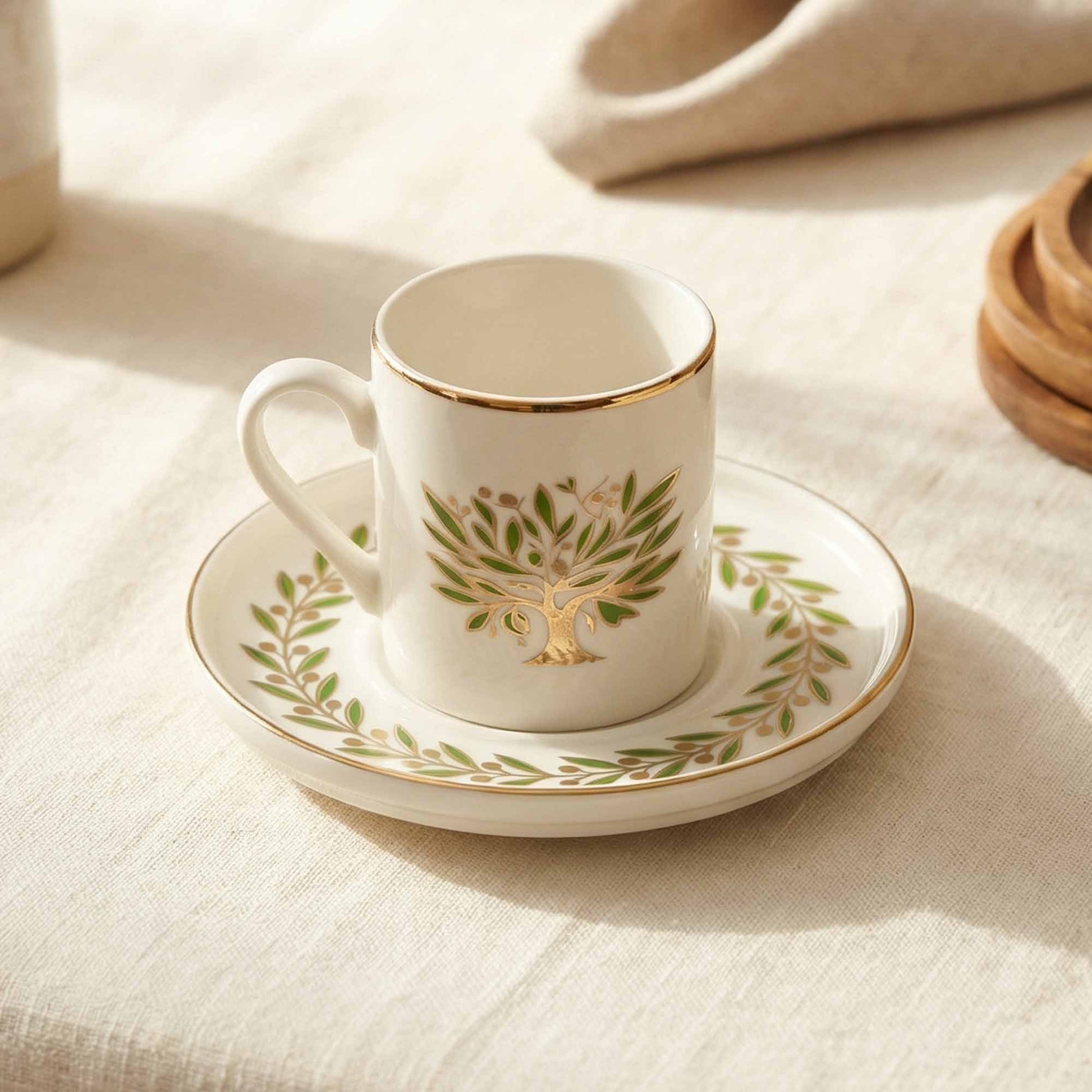 Porcelain cup and saucer with tree design on a beige fabric background
