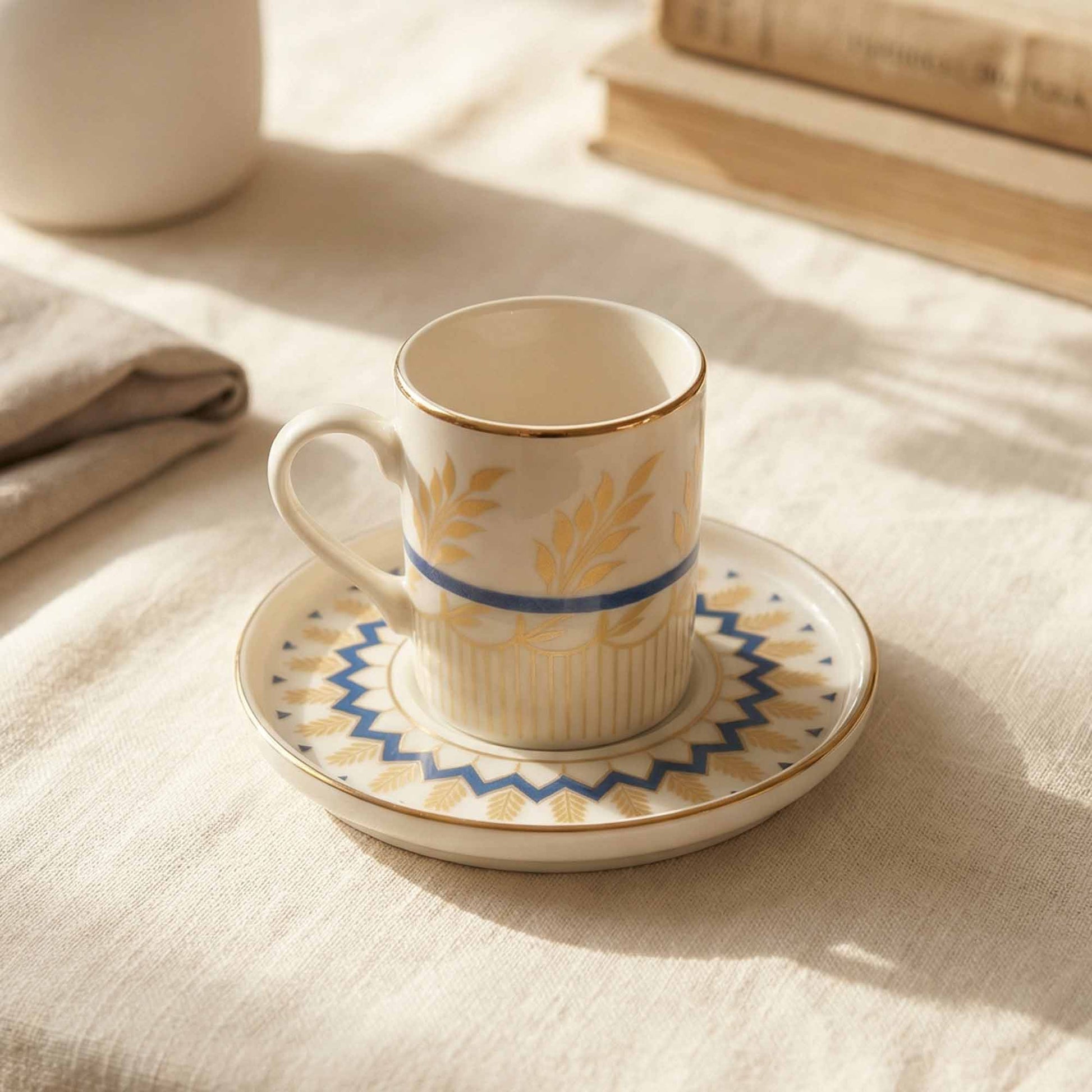 Porcelain cup and saucer with decorative patterns on a textured surface