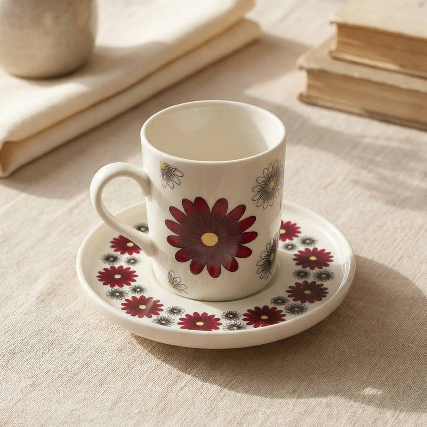 Porcelain cup and saucer with floral design on a textured surface