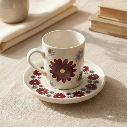 Porcelain cup and saucer with floral design on a textured surface