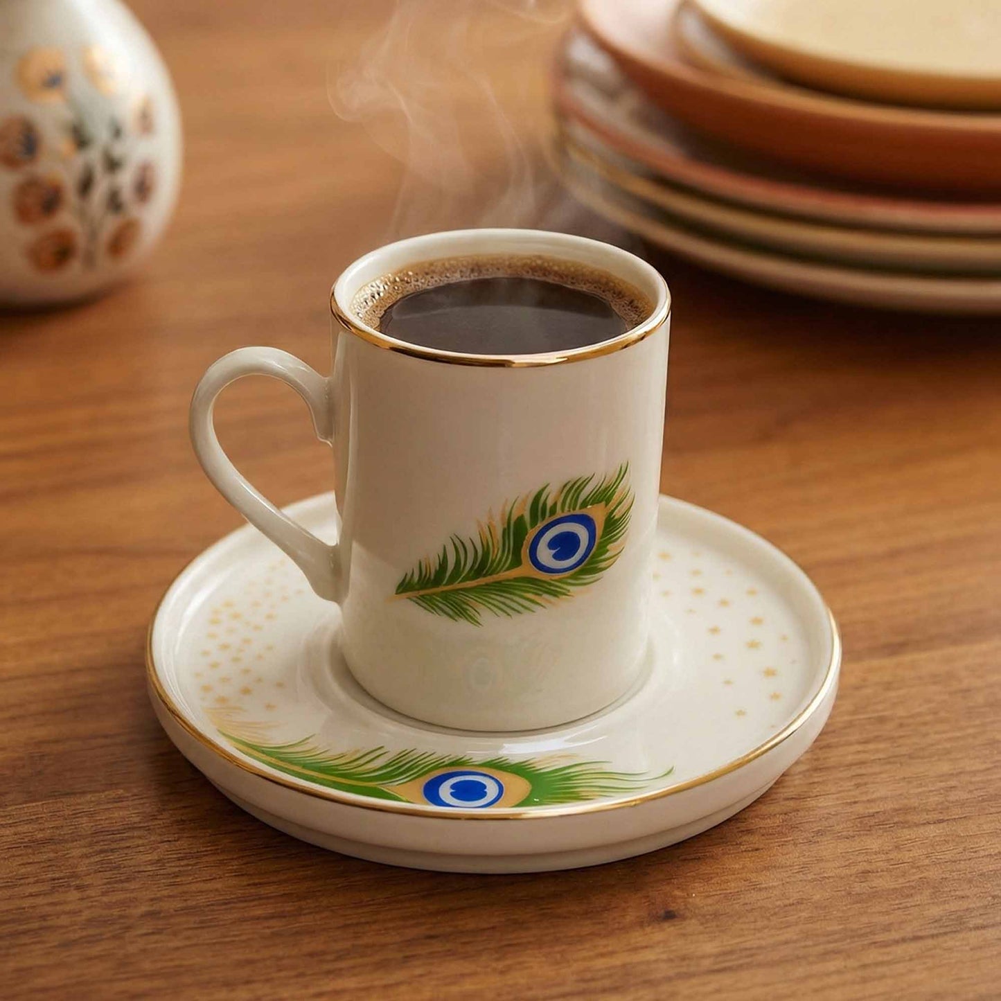 Cup of coffee with a peacock feather design on a saucer, placed on a wooden table.