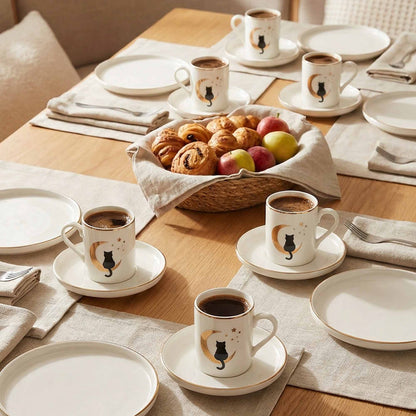 Table setting with coffee cups, plates, and pastries on a wooden table.