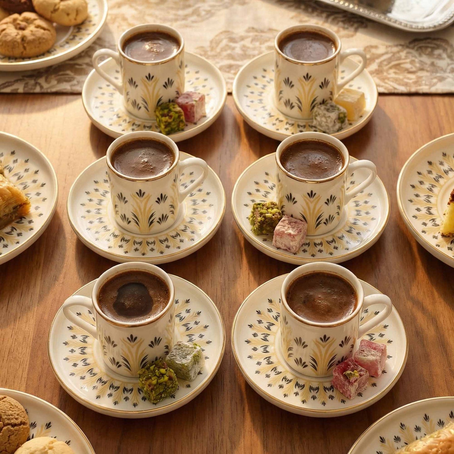 Coffees served in decorative cups with saucers on a wooden table.