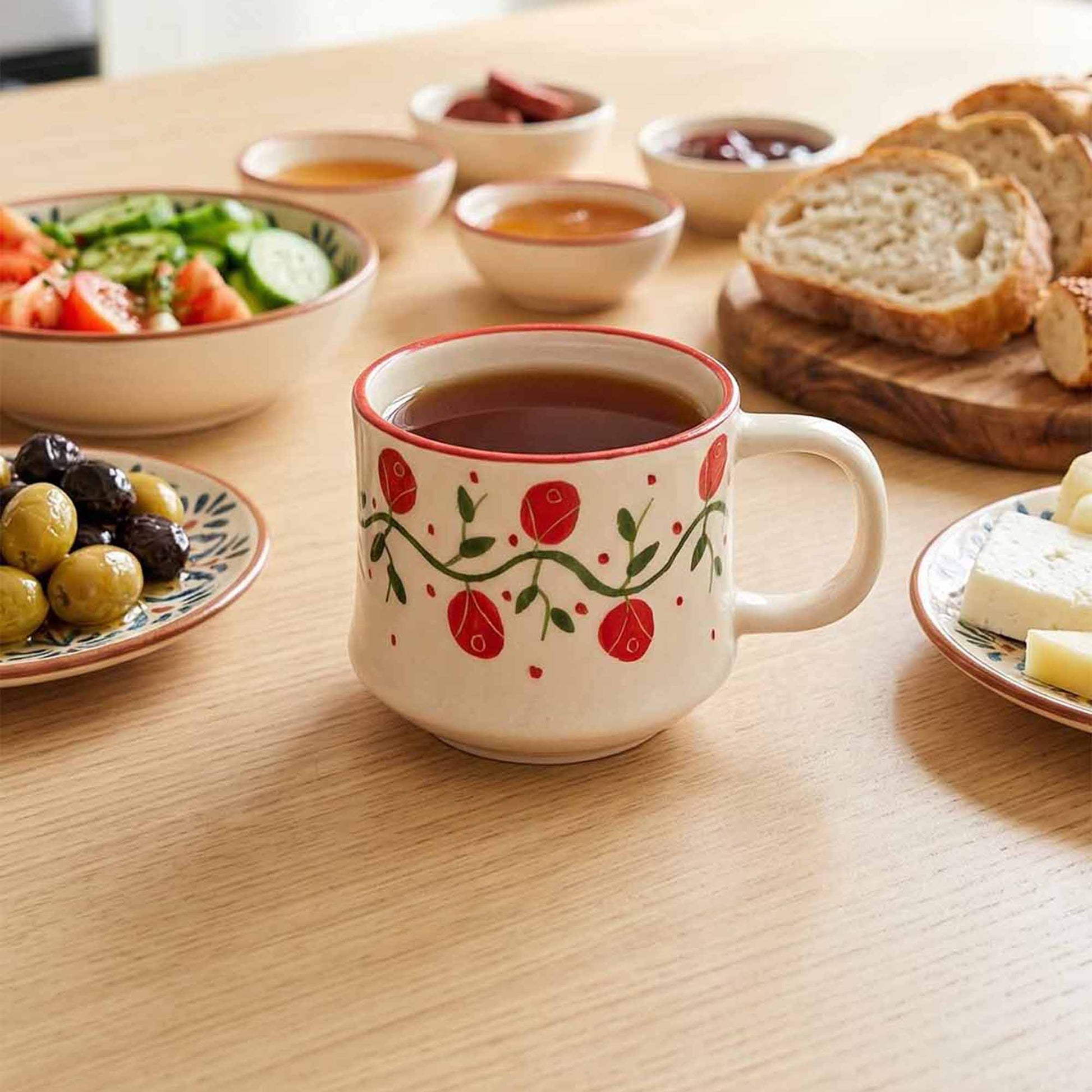Ceramic mug with floral design on a table with food items