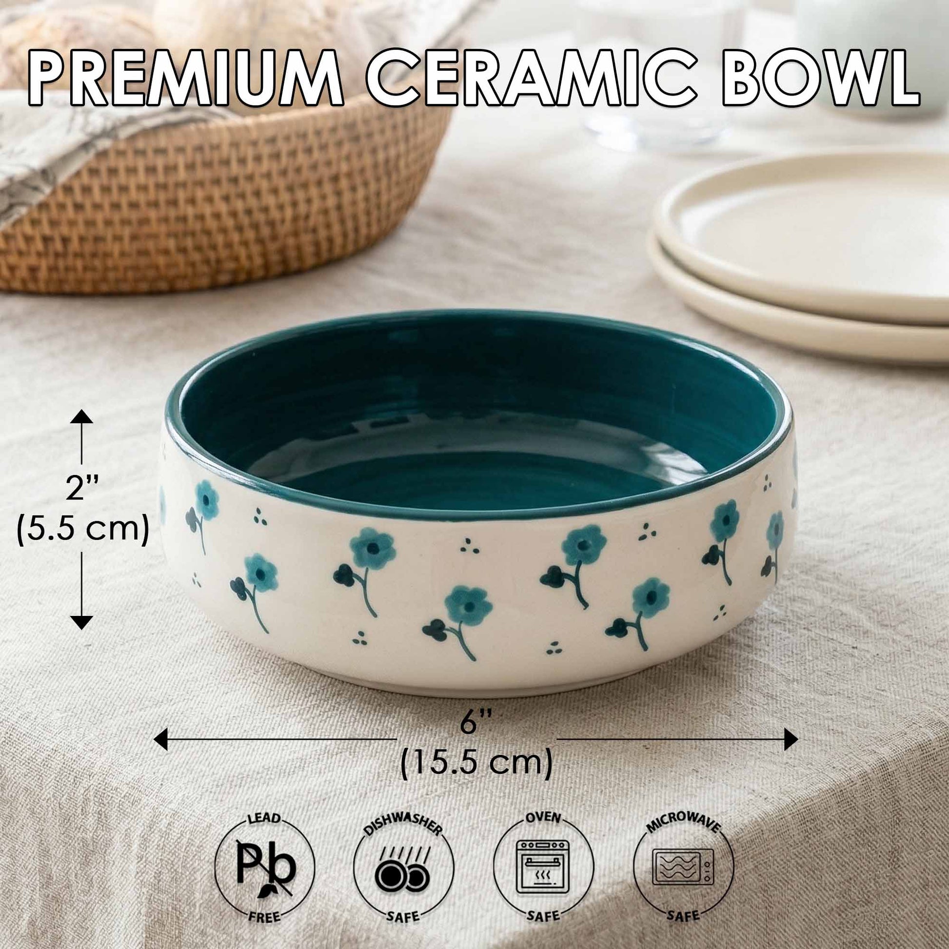 Teal and white ceramic bowl with floral design on a beige surface, showing measurements and safety icons.