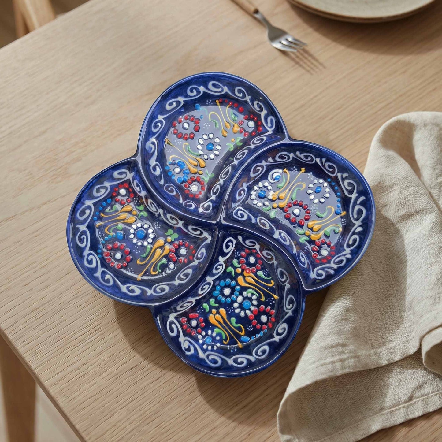 Decorative blue serving tray with colorful patterns on a wooden table.