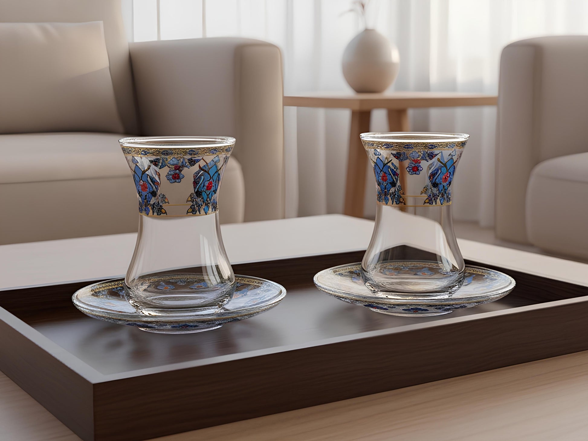 Two glass cups with floral designs on a dark wooden tray in a living room setting.