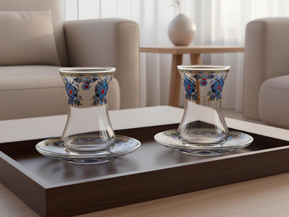 Two glass cups with floral designs on a dark wooden tray in a living room setting.