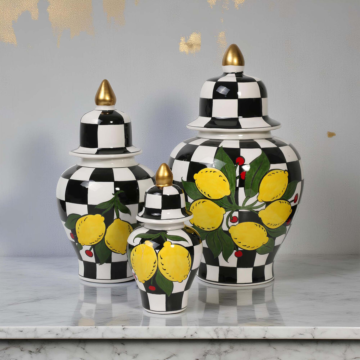 Set of three decorative jars with black and white checkered pattern and lemon design on a marble surface.