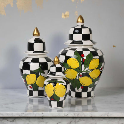 Set of three decorative jars with black and white checkered pattern and lemon design on a marble surface.