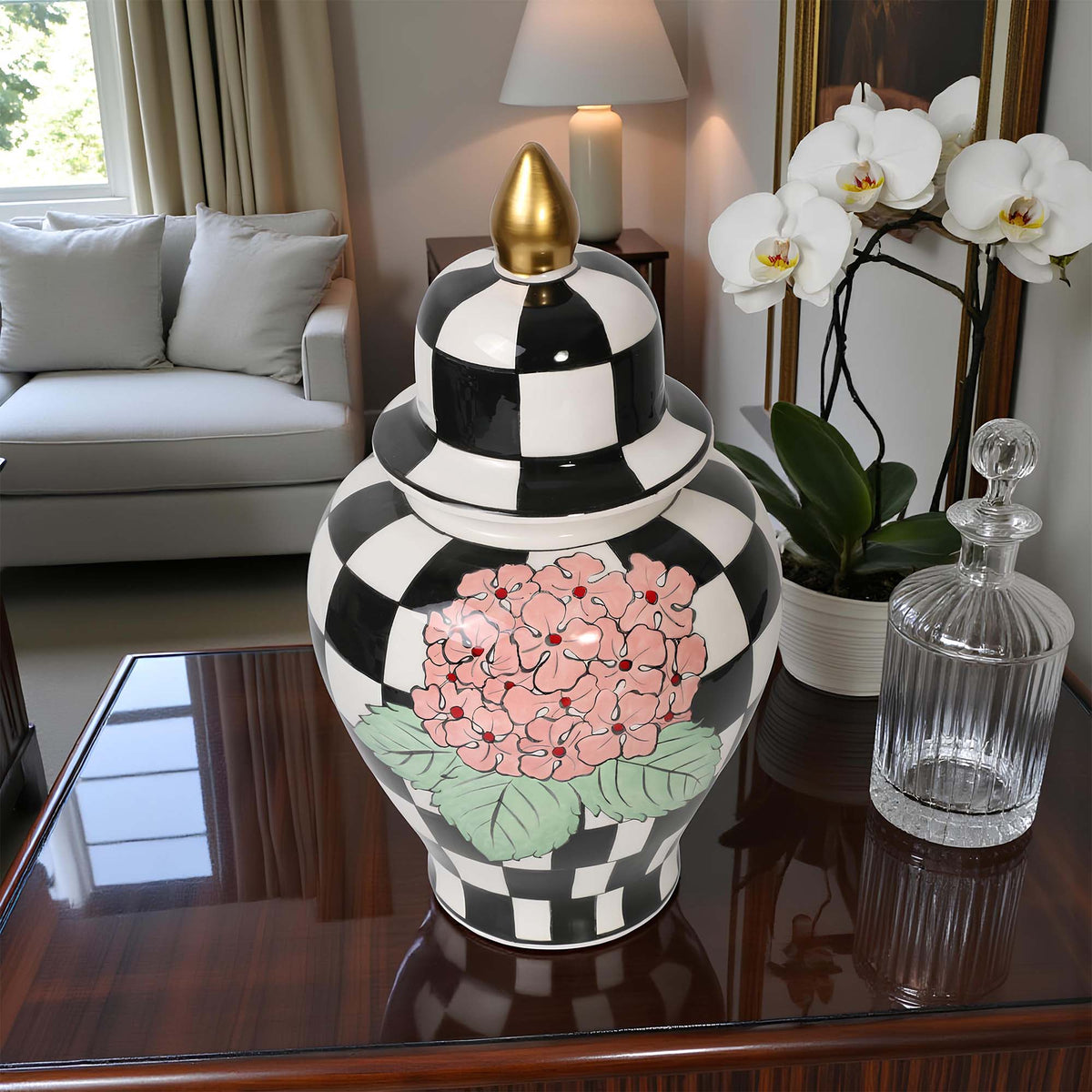 Decorative black and white checkered jar with floral design on a table in a living room.