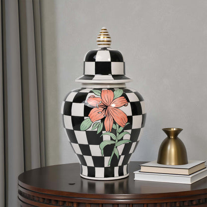 Decorative vase with black and white checkered pattern and floral design on a wooden table.