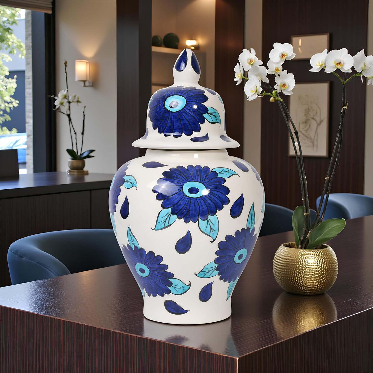 Decorative jar with blue floral patterns on a table in a room with chairs and a window.