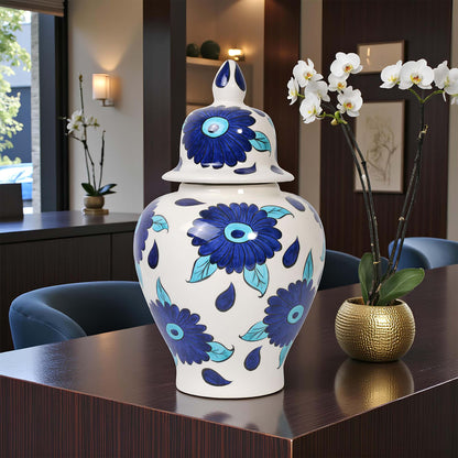 Decorative jar with blue floral patterns on a table in a room with chairs and a window.