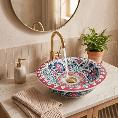 Decorative floral-patterned sink with running water in a bathroom setting.