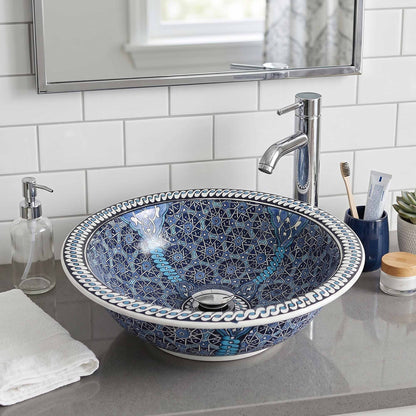Bathroom sink with decorative blue and white pattern, faucet, and toiletries.