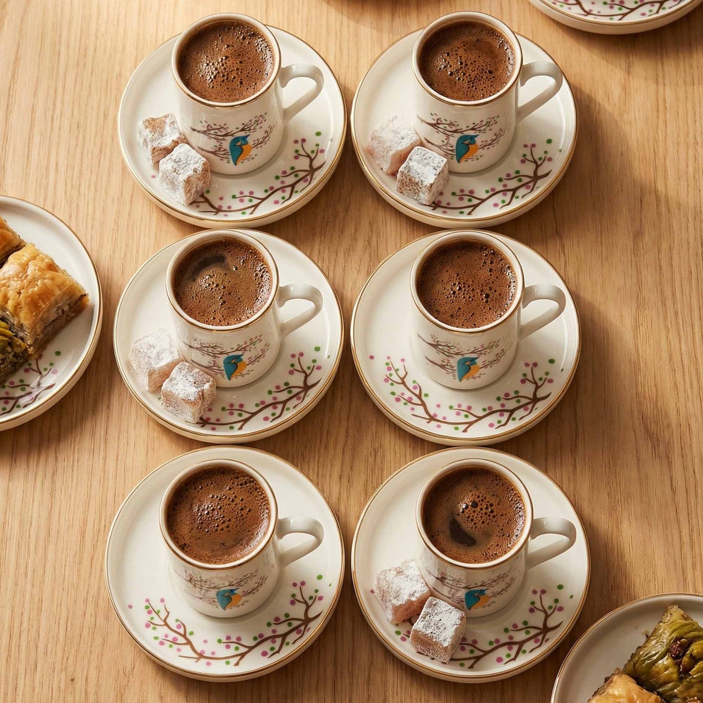Café au lait served in decorative cups with saucers on a wooden table.