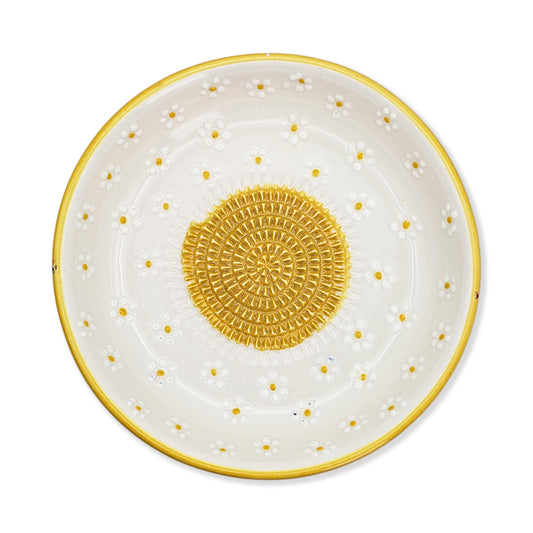 Decorative garlic grater bowl with yellow polka dots and center design on a white background