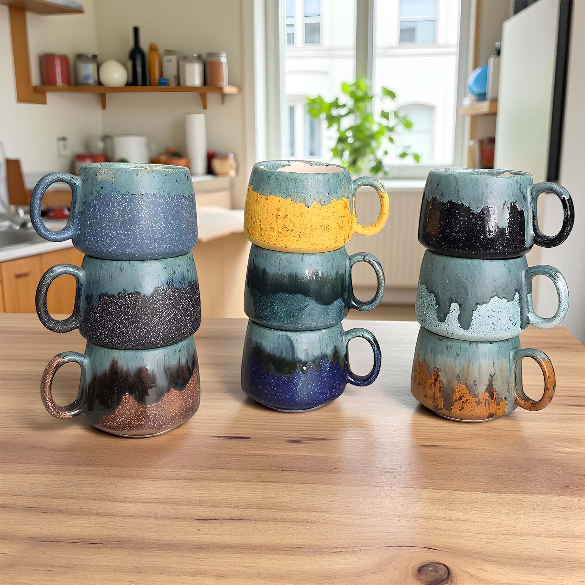 Stacked ceramic mugs with unique glaze patterns on a wooden surface.