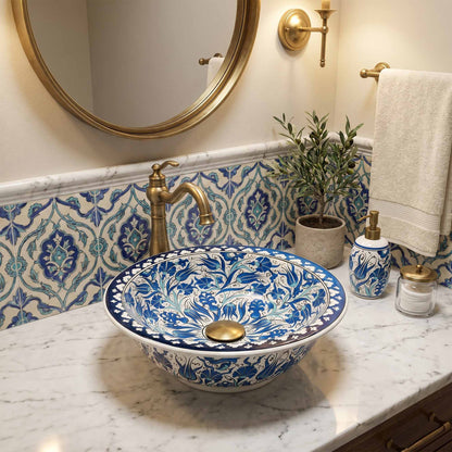Decorative blue and white sink with gold fixtures in a bathroom setting.