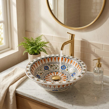Decorative ceramic sink with a gold faucet in a bathroom setting.