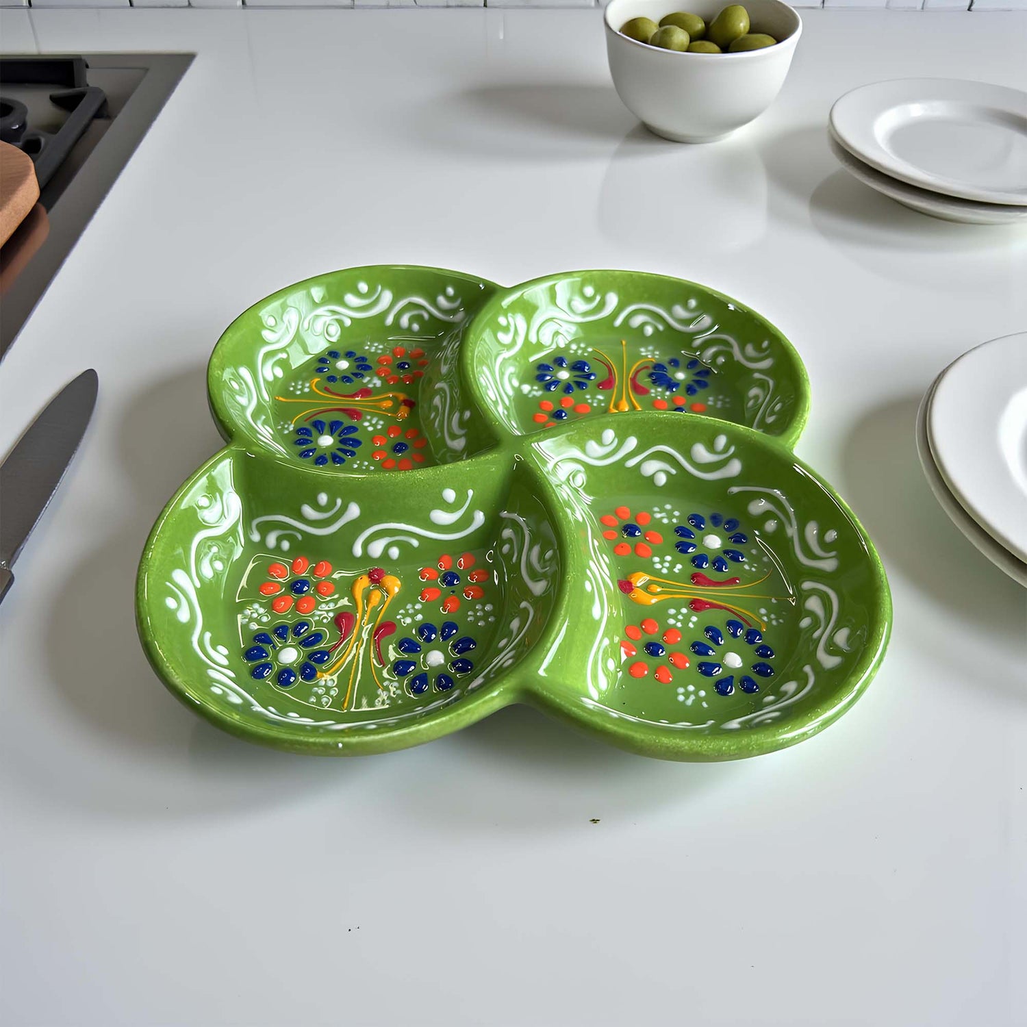 Green ceramic plate with floral patterns on a white countertop
