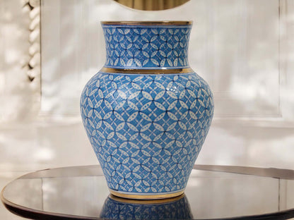 Blue ceramic vase with white patterns on a reflective surface