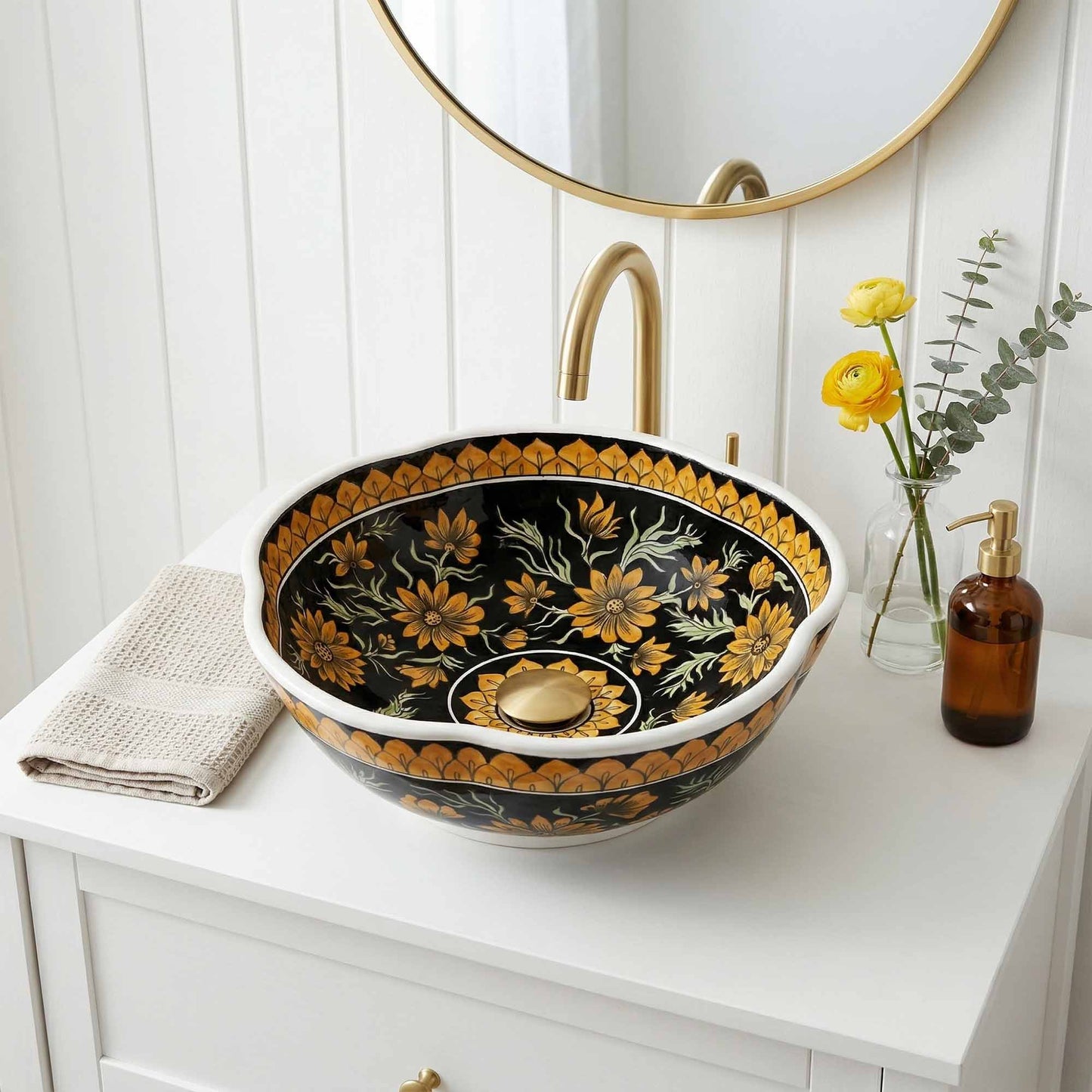 Decorative floral-patterned ceramic sink on a bathroom counter with a mirror and flowers.