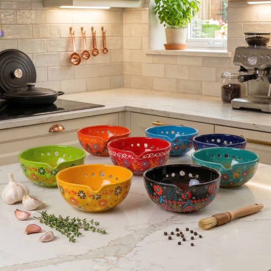 Colorful ceramic herb stripping bowls on a kitchen counter with kitchen utensils and appliances in the background